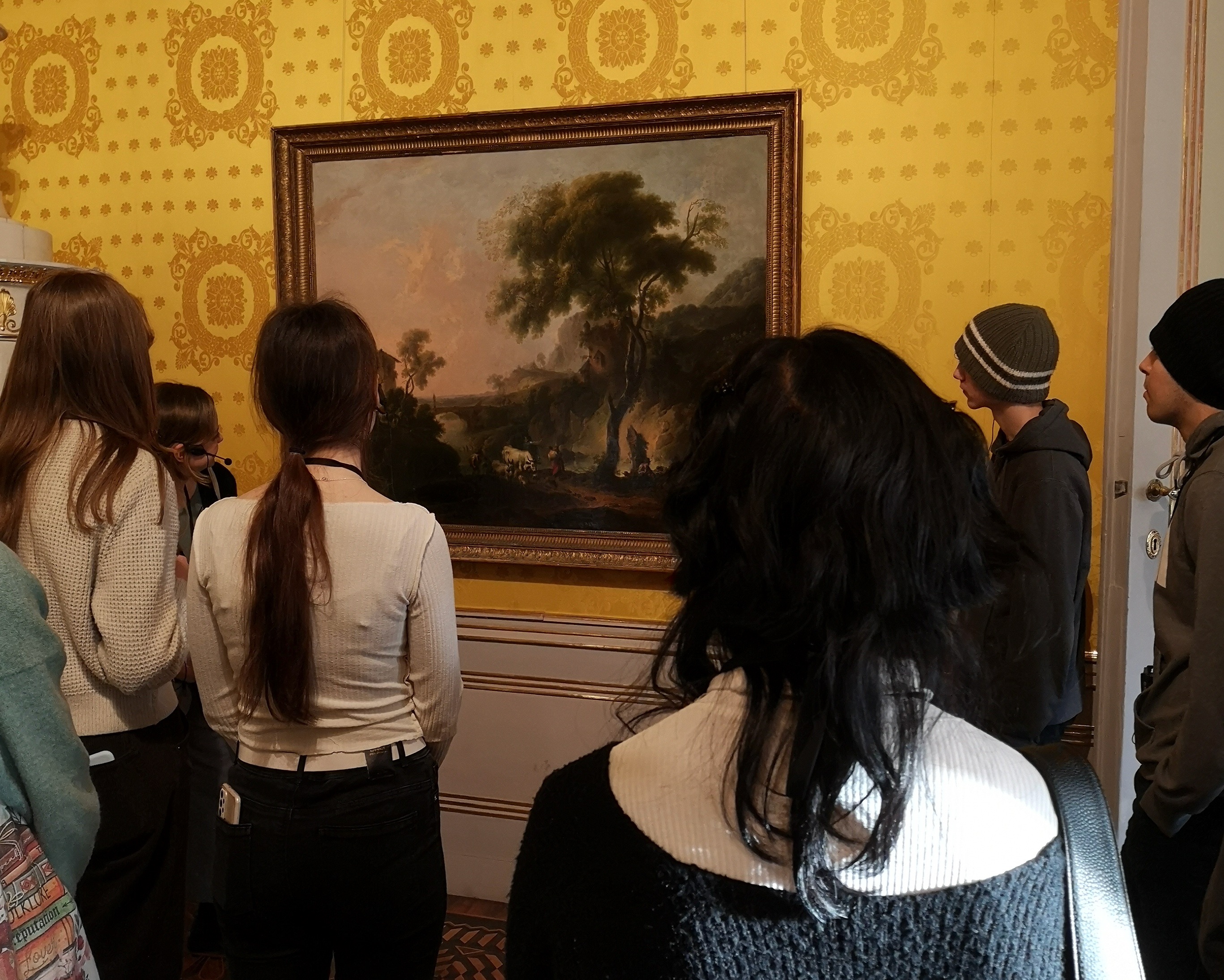 SchuelerInnen betrachten ein realistisches Gemaelde.