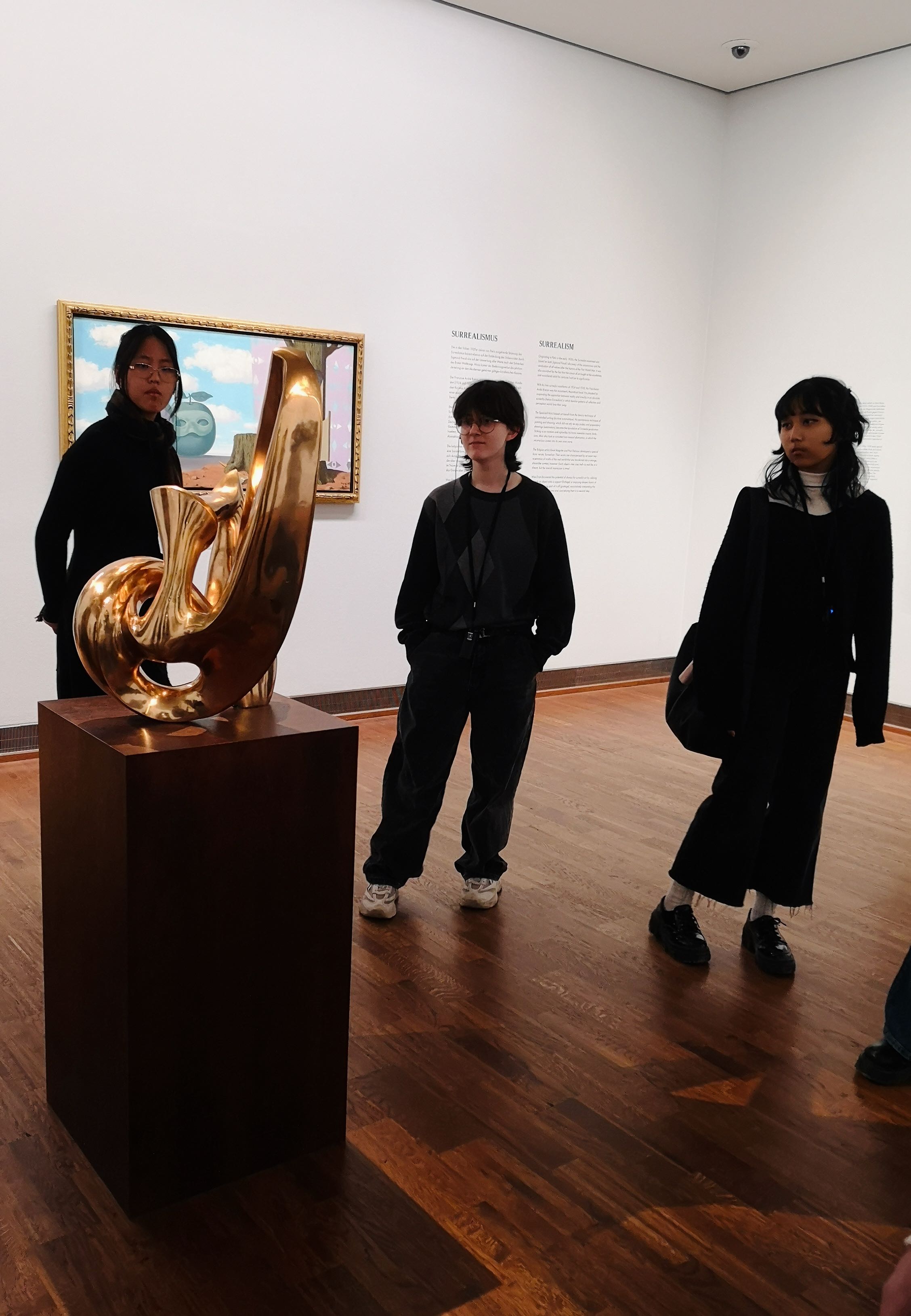 SchuelerInnen betrachten eine surrealistische Plastik.